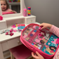 Child's hand holding a pink Barbie hair accessory set in front of a vanity with toys - KWtoyszone | Proudly Canadian